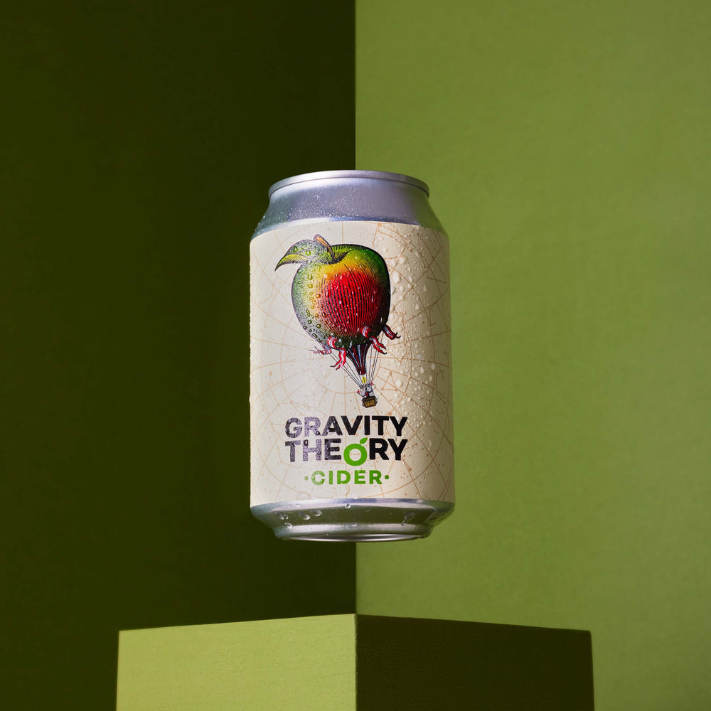 Gravity theory cider can on green background