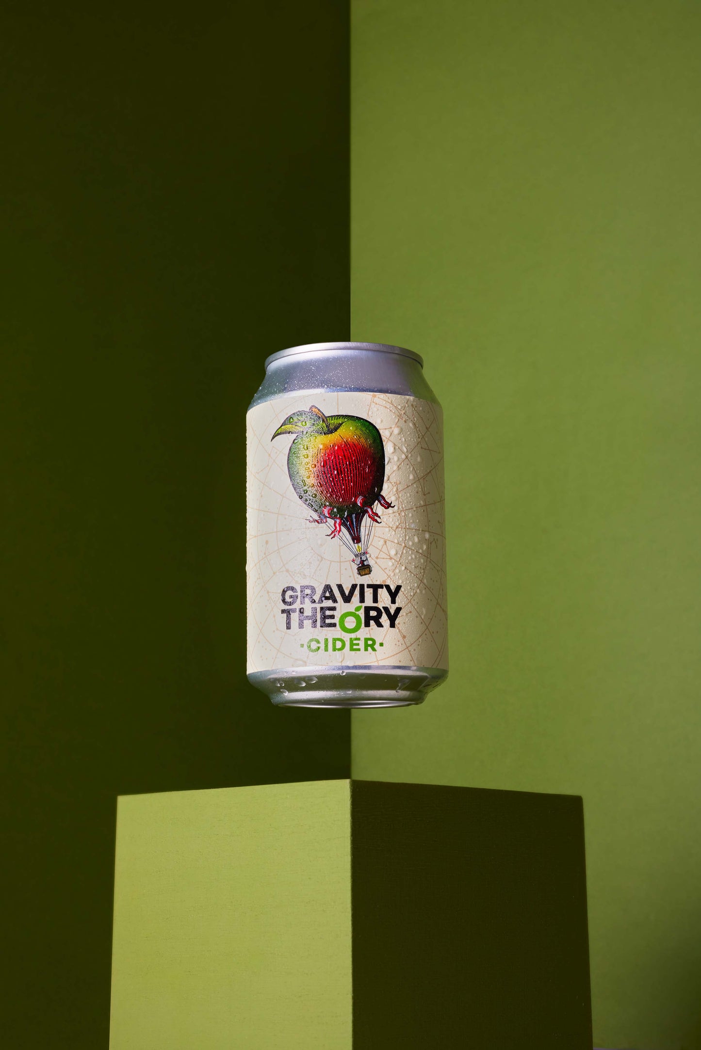 Gravity theory cider can on green background
