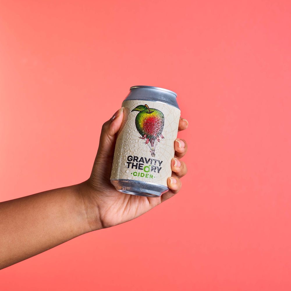 Gravity theory cider can on peach background