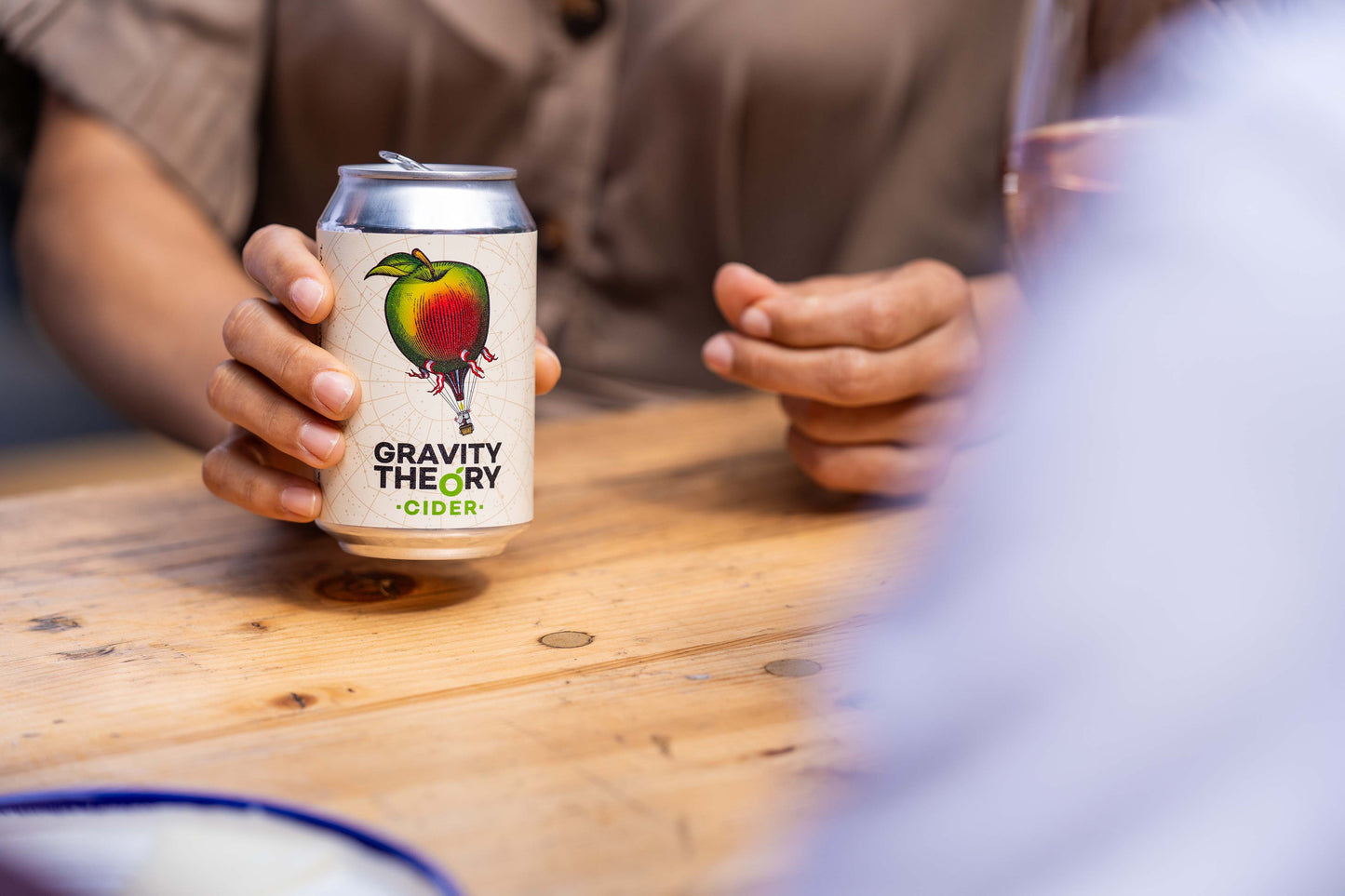 Gravity Theory Cider woman holding can